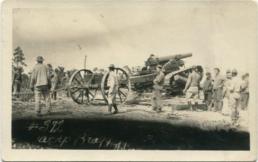 Real-photo postcard of a photograph of an unidentified field artillery crew standing around an artillery gun on the firing range at Camp Bragg, N.C., taken between 1918