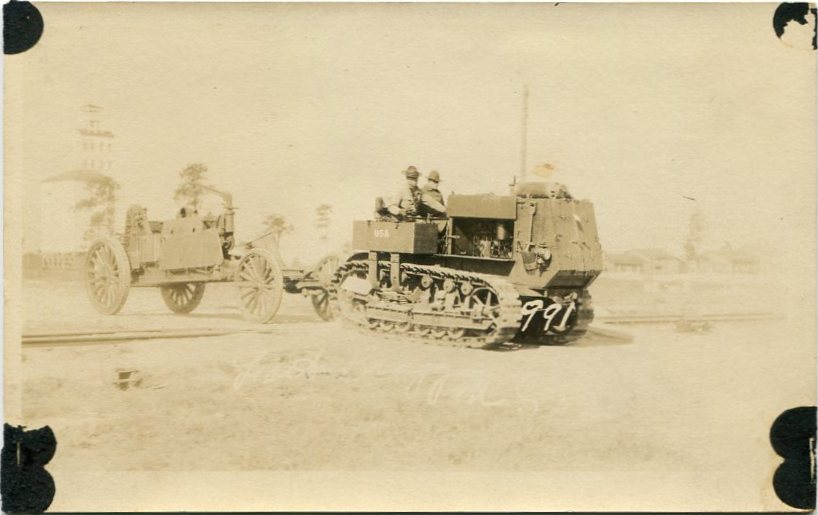 Real-photo postcard of a photograph of a U.S. Army 10-ton tractor pulling a cart across railroad tracks at Fort Bragg, N.C., around the 1920s [circa 1920s].