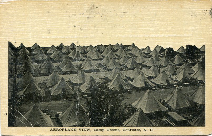 Picture postcard of an aeroplane view of U.S. Army tent areas and camp streets at Camp Greene, N.C., during World War I. Postcard contains message from an Army soldier named John to Murray Upson of New Haven, Connecticut [circa 1910s] [Postcard by: A. M. Simon of New York City].