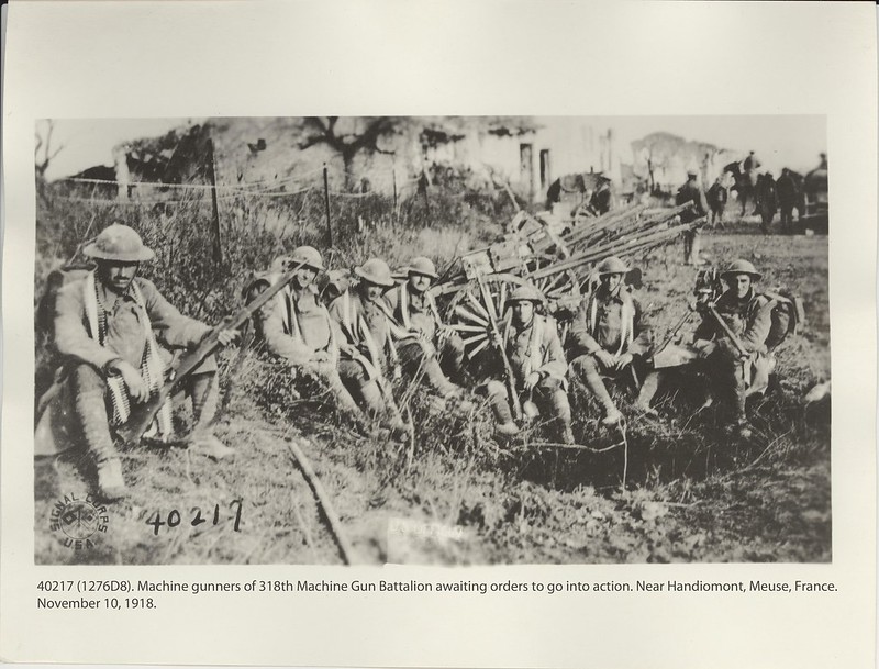 mgPhotograph of machine gunners of the 318th Machine Gun Battalion sitting on the ground, awaiting orders to go into action near Haudiomont, France, on November 10. 1918.